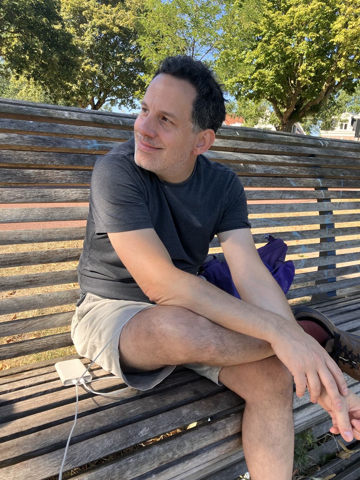 Jay Tavares sitting on a park bench on a sunny day